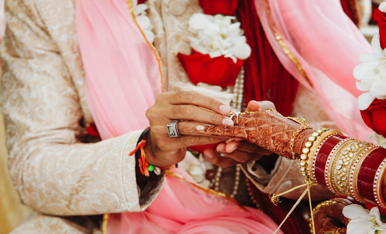 groom putting ring to bride